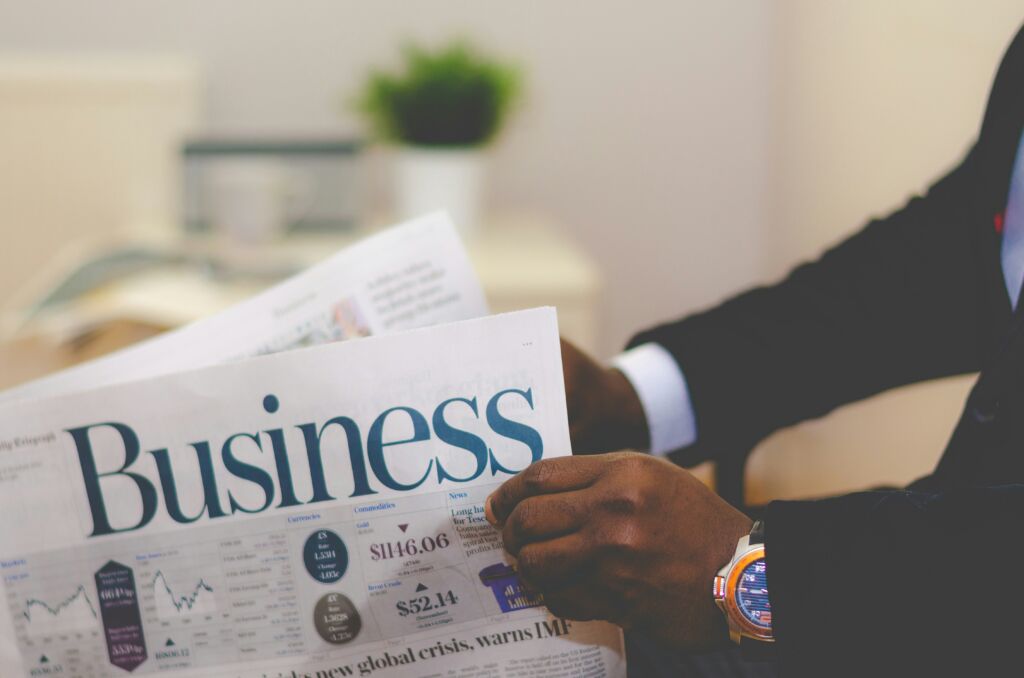 A business energy broker reading the financial section of a newspaper, focusing on energy markets and industry trends.