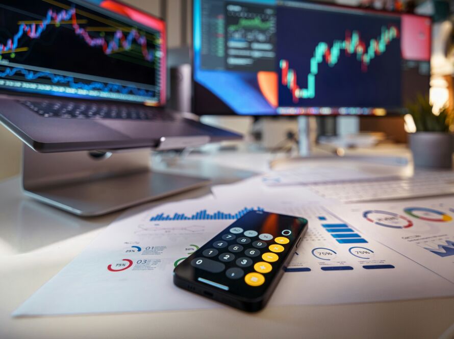 "Calculator and documents displaying energy charts and graphs, representing utilities pricing analysis for a business electricity broker.