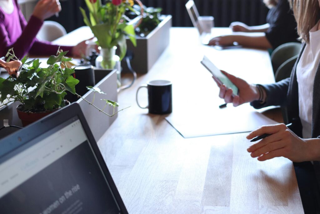 A business meeting between an energy broker and a client, represented by two people shaking hands over a table with documents and graphs.